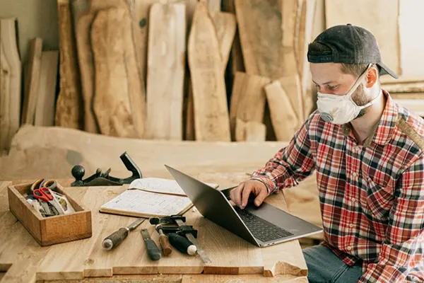A woodworker operating a laptop.