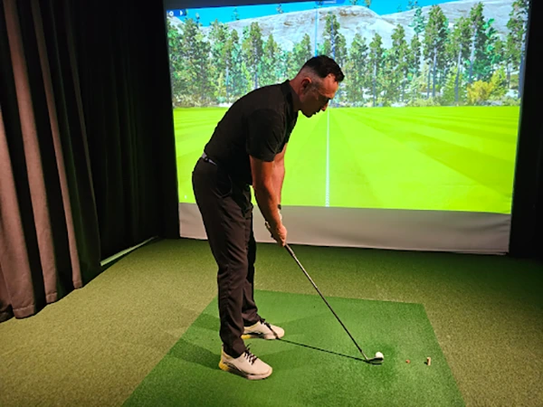 An employee using the indoor golf simulator
