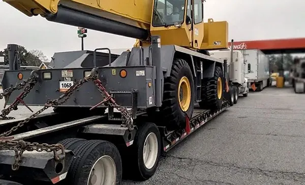 Heavy crane transported on flatbed trailer