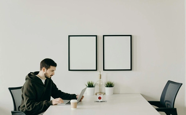 Man working on a laptop in a minimalist office.